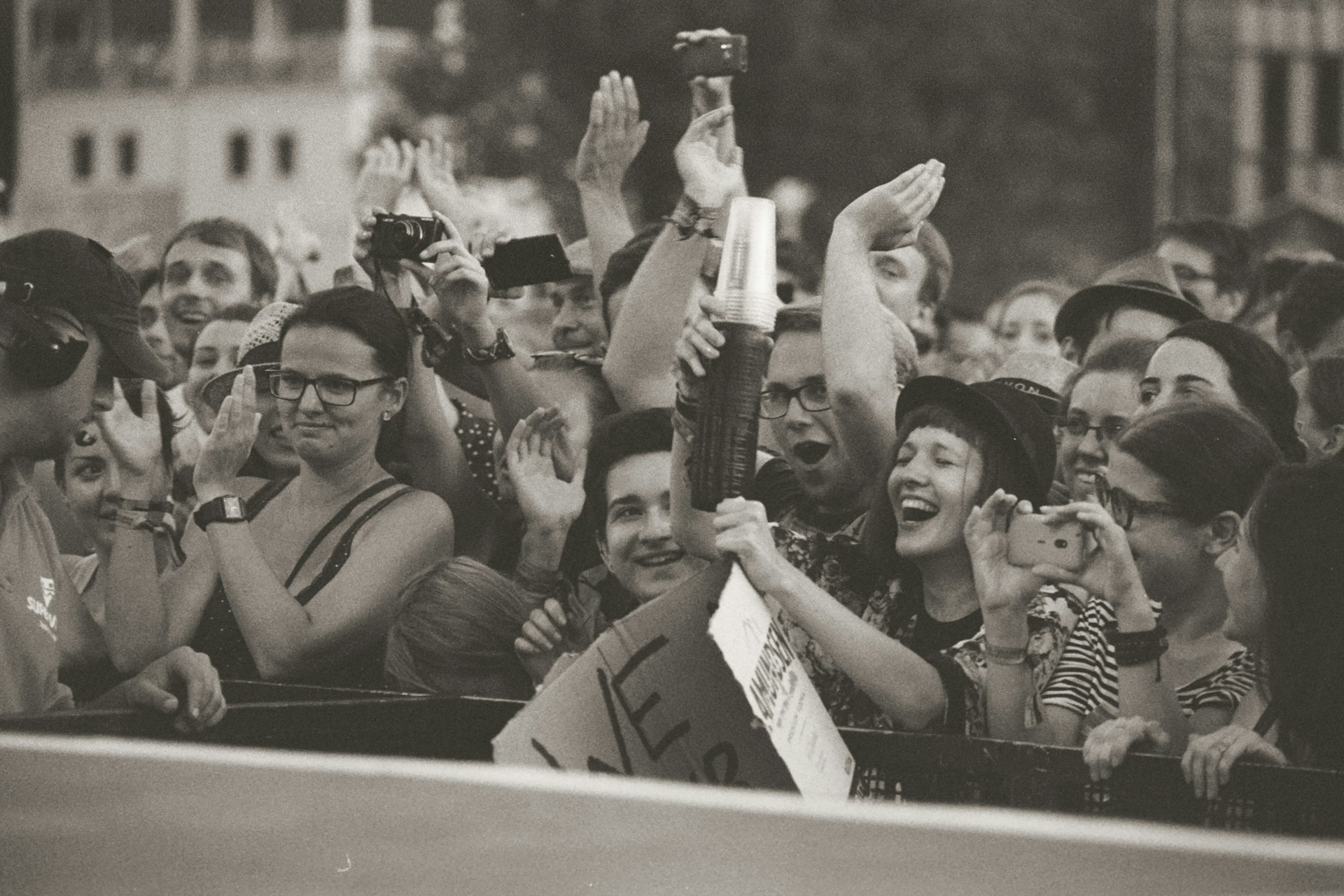 A crowd of people are taking pictures with their cell phones
